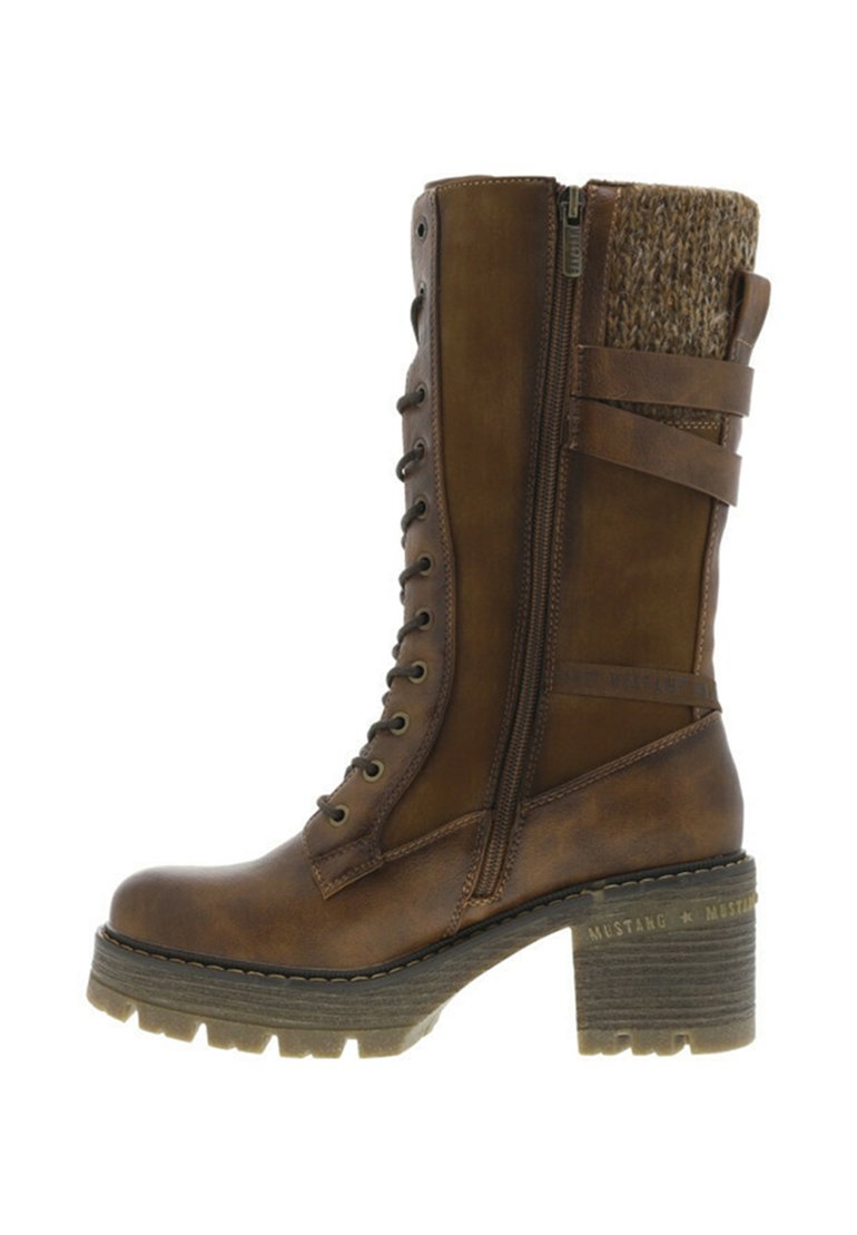 Bottine en cuir marron avec un col en tricot texturé, des lacets à l'avant et une fermeture éclair sur le côté. Talon épais avec semelle crantée et détails discrets de la marque.