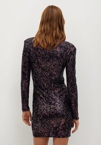 Robe courte et ajustée en tissu sombre recouverte de sequins multicolores. Manches longues et col montant. Vue de dos montrant une silhouette lisse.