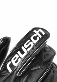 Black goalkeeper gloves with textured grip surfaces and white accents. Features a prominent black and white logo on the wrist area.