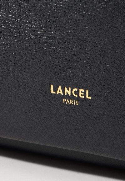 Черен кожен несесер с текстурирана повърхност, с релефно златно лого "LANCEL PARIS" за забележителен детайл.
