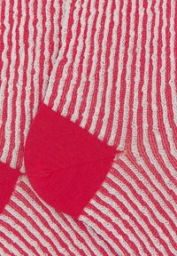 Calze a righe rosse e bianche con un motivo a maglia testurizzata e punta rossa uniforme. Materiale morbido con un design a coste in tutto.