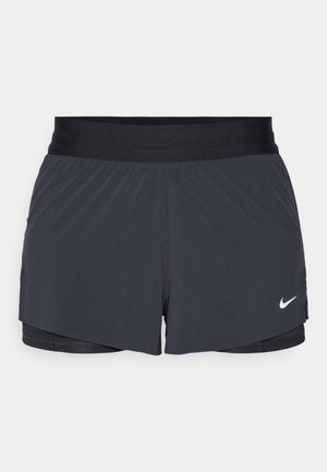 Sort træningsshorts med elastisk talje, der har et lagdelt design og et lille hvidt Nike-logo nederst til venstre. Letvægtsmateriale.