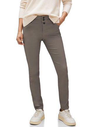 Graue Slim-Fit-Hose aus einem glatten Stoff; mit hoher Taille, drei Knöpfen und Seitentaschen. Kombiniert mit weißen Sneakers.