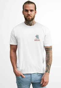 Weißes Baumwoll-T-Shirt mit einem bunten Grafikdruck eines Leoparden und dem Text "NVLS CO" auf der linken Brust. Weicher Stoff, kurze Ärmel, runder Kragen.