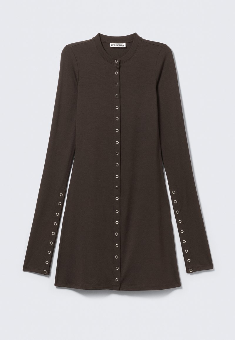 Robe boutonnée à manches longues en brun foncé avec col rond et œillets métalliques courant sur le devant et les manches.