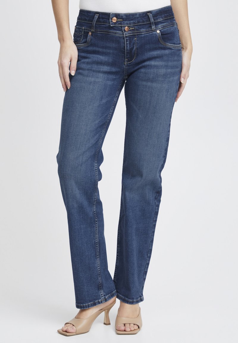 Jeans de mezclilla azul oscuro con un diseño de pierna recta, estilo de cinco bolsillos, costuras en contraste y herrajes en tono cobre.