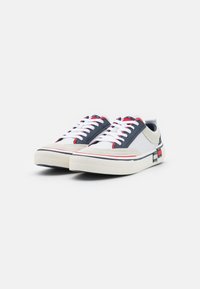 Sneakers con una combinazione di colori navy blu, bianco e grigio. Lacci bianchi, tomaia testurizzata e accenti rossi in contrasto. Suola in gomma spessa.