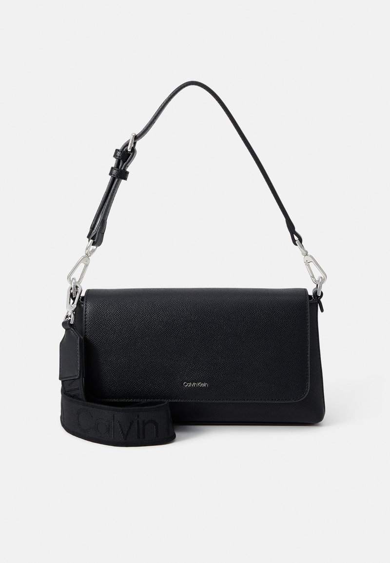 Čierna kožená crossbody taška s textúrovaným povrchom, magnetickým uzáverom a odnímateľným popruhom s logom "Calvin Klein". Strieborné kovanie.