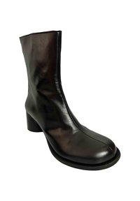 Bota de tobillo de cuero negro con punta redondeada, tacón block delgado y diseño sin costuras. Textura suave con un acabado brillante.