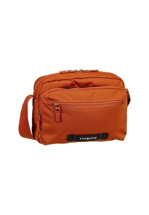 Borsa a tracolla arancione in canvas con tasca frontale con zip, tracolla regolabile e patch logo. Caratterizzata da una texture liscia e un design minimalista.