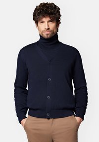 Granatowy sweter kardigan z wysokim kołnierzem, dekoltem w kształcie litery V i pięcioma guzikami z przodu. Posiada długie rękawy oraz dopasowany pas.