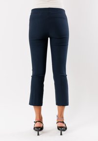 Pantaloni capri blu navy realizzati in materiale elasticizzato, con un design aderente e lunghezza corta, caratterizzati da una texture liscia e senza motivi visibili.