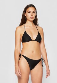 Čierny bikiny set s trojuholníkovým topom so šnurovaním a nastaviteľnými bočnými nohavičkami, vyrobený z hladkej a elastickej látky.