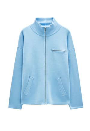 Jasnoniebieska kurtka zapinana na zamek błyskawiczny z wysokim kołnierzem, z ribbowanymi mankietami, dwoma przednimi kieszeniami oraz małą kieszonką na zamek na piersi. Miękka tekstura.
