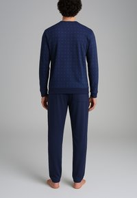 Set di pigiama da uomo in navy con una parte superiore a motivo puntinato e pantaloni a tinta unita con tasca posteriore. Realizzato in tessuto morbido e leggero.