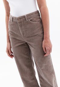 Bruine corduroy broek met een rechte pijpontwerp, voorzien van een knoopsluiting, riemlussen en zijzakken, met verticale ribbelstructuur.