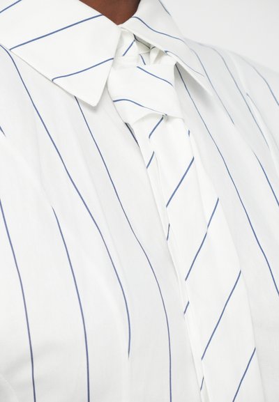 White shirt with thin vertical blue stripes featuring a matching striped fabric knot around the collar.