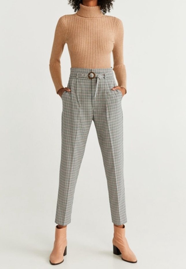 Geribbelde tan-coloured coltrui gecombineerd met grijs geblokte high-waisted broek met een riemlus en ronde gesp, aangevuld met roze enkellaarsjes.