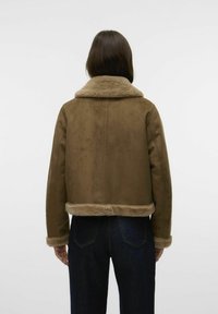 Giacca in suede marrone con un morbido colletto e polsini in pelliccia sintetica beige. Design corto e superficie testurizzata con dettagli di cucitura visibili.