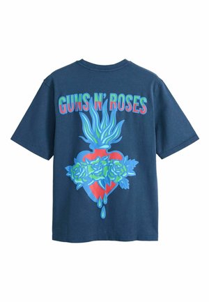 Tumesinine t-särk, millel on tekst "Guns N' Roses" üleval punase südame graafika kohal, mis on mähitud siniste rooside ja siniste leeki meenutavate kujundustega ülaosas.