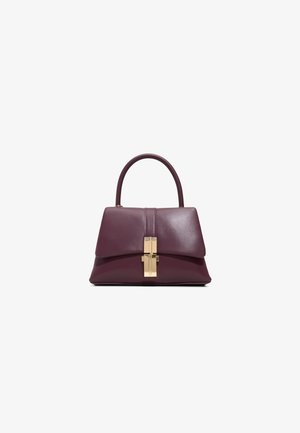 Sac structuré en cuir bordeaux profond avec une texture lisse. Il est doté d'un fermoir à verrouillage doré et d'une poignée arrondie.