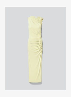 Robe longue sans manches jaune pâle avec détail froncé sur le côté et tissu rassemblé maintenu par un petit anneau sur une épaule.