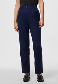 Jūras zila pielāgota bikses ar platu priekšpusi, divām sānu kabatām un vienu pogu aizdari. Pabeigtas ar taisnu kāju dizainu.