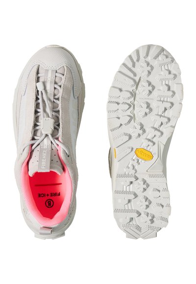 Baskets gris clair avec intérieur rose, système de blocage des lacets élastique, accents en daim, et semelle Vibram robuste avec des rainures profondes pour une meilleure adhérence.