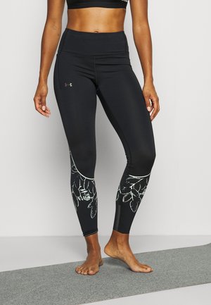 Leggings neri con motivi floreali in verde chiaro. Design a vita alta, texture liscia e lunghezza alla caviglia. Logo Under Armour sul lato.