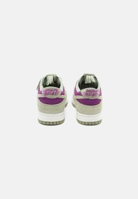 Nike sneakers featuring a textured gray and purple design, with a knit green lining and green outsole, showcasing unique hardware details.