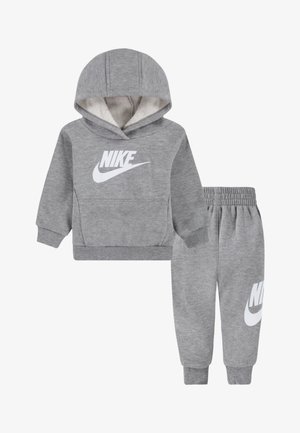 Ensemble sweat à capuche et pantalon de survêtement Nike gris. Le sweat à capuche possède une poche kangourou et un logo blanc ; le pantalon est doté d'une taille élastique et de poignets élastiqués.