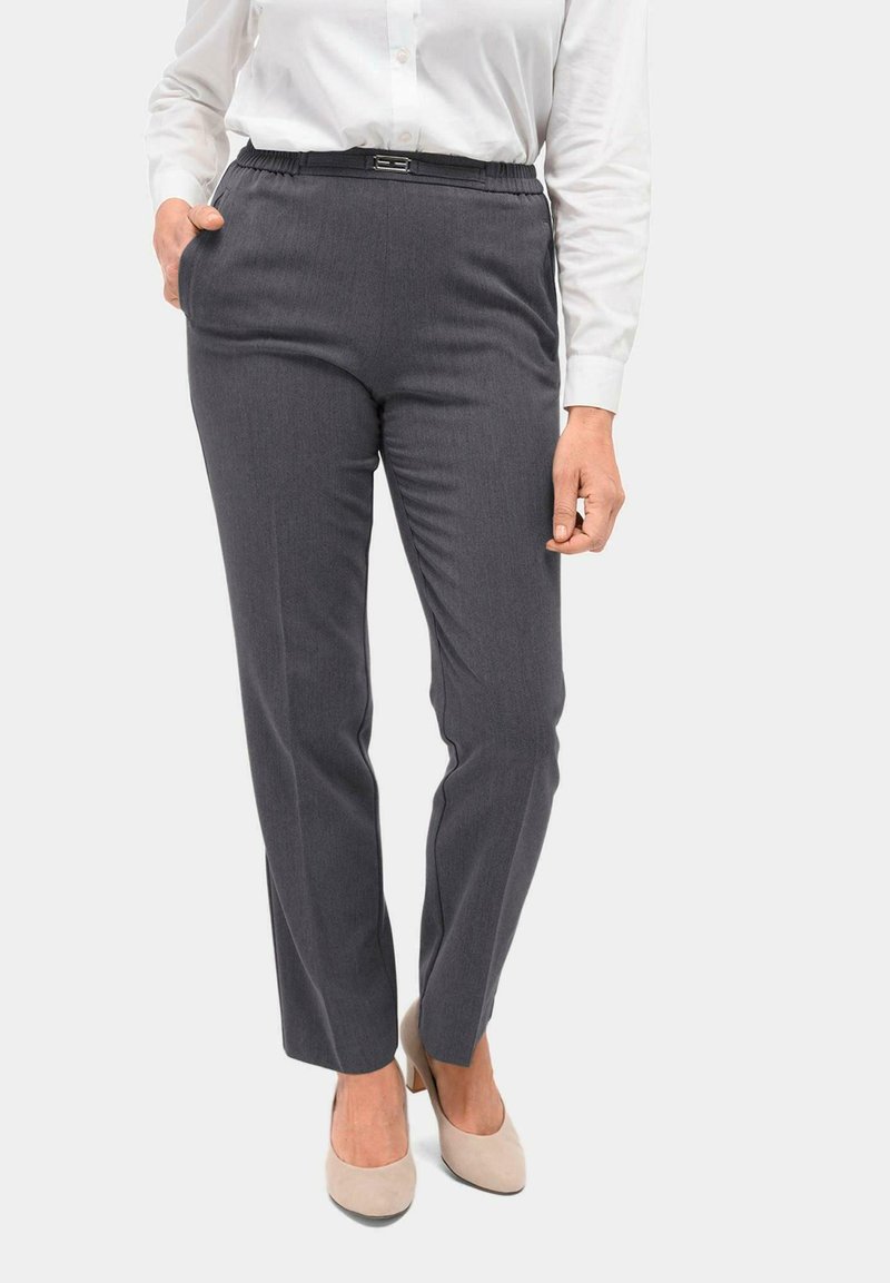 Grijze op maat gemaakte broeken met een elastische tailleband, twee zijzakken en een slim fit, gecombineerd met een witte blouse en beige hakken.