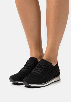 Czarne buty sportowe z dzianinową cholewką, okrągłym noskiem, sznurowanym zapięciem oraz srebrnym akcentem na międzypodeszwie. Teksturowany wzór po bokach.