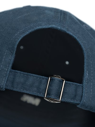 Căciulă de culoare bleu marin, fabricată din denim, cu un vârf curbat, curea ajustabilă cu cataramă din metal argintiu și țesătură texturată.