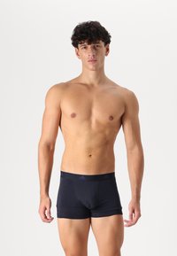 Námornícky modré boxerky vyrobené z mäkkého, elastického materiálu, s širokým pásom a nenápadným logom, navrhnuté na priliehavé nosenie.
