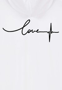 Felpa bianca con un design di testo scritto a mano in nero che dice "amore" combinato con una linea del battito cardiaco. Texture liscia, stile casual.