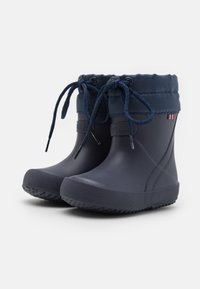 Botas de lluvia de goma en color navy con puño de tela, cierre con cordones, suela texturizada y detalle de logotipo. Acabado suave con un diseño de panel reforzado.