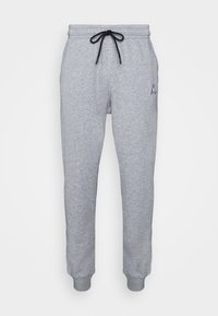 Graue Sweatpants mit einem Zugbandbund, gerippten Bündchen und einem kleinen schwarzen Logo am linken Bein. Hergestellt aus einem weichen, strukturierten Stoff.