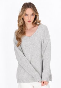 Hellegrauer gestrickter Pullover mit V-Ausschnitt, lockerer Passform und langen Ärmeln mit gerippten Bündchen. Weiche Textur mit gemütlichem Erscheinungsbild.