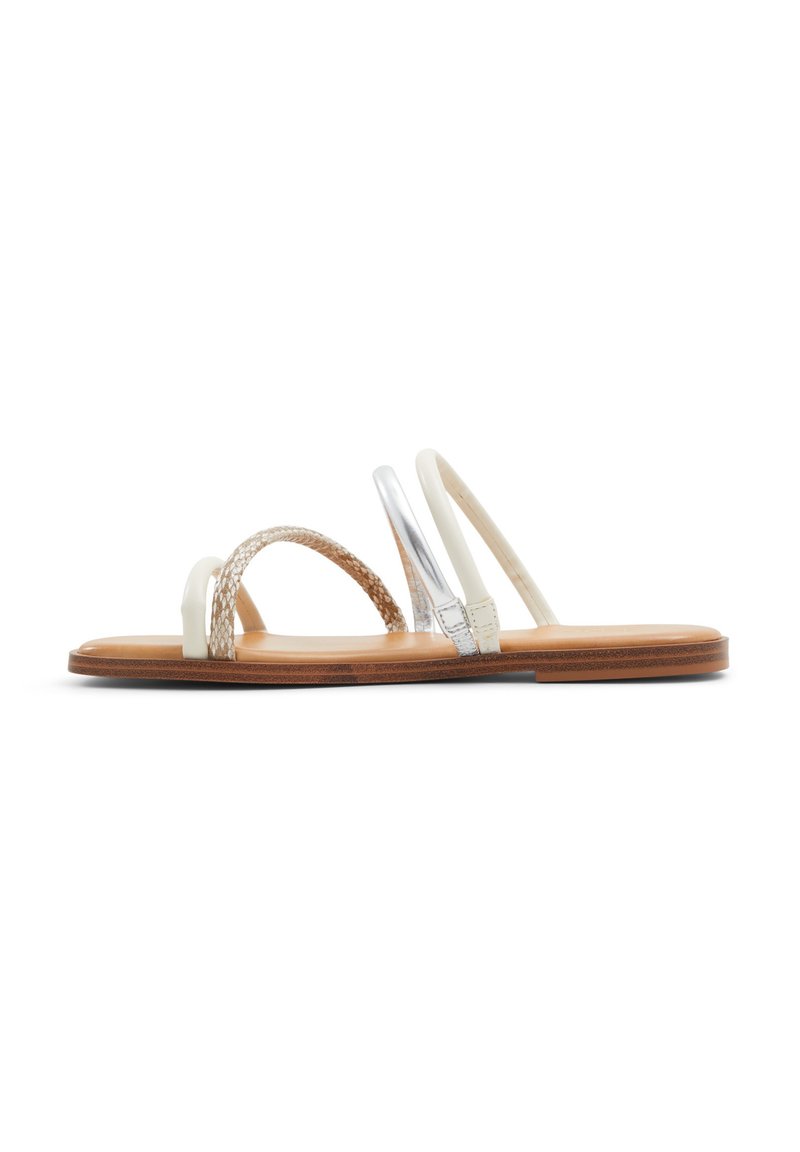 Płaskie sandały z brązową drewnianą podeszwą, białymi paskami, plecionym akcentem oraz błyszczącym srebrnym detalem na jednym pasku. Gładka tekstura na całej powierzchni.