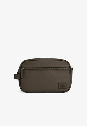 Trousse de toilette rectangulaire en cuir marron foncé avec une poche zippée à l'avant, une poignée latérale et un petit patch logo de la marque cousu.