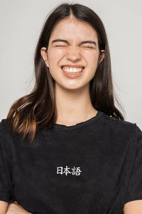 Čierne bavlnené tričko s bielymi japonskými znakmi. Tričko má voľný strih a krátke rukávy, s jemným, textúrovaným vzhľadom.