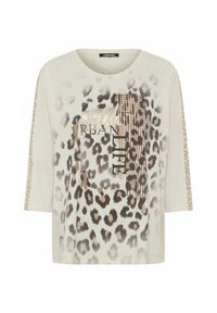 Beige, losse fit t-shirt met een groot luipaardpatroon en de tekst "Urban Life". Korte mouwen met luipaardpatroon accenten aan de zijkanten.