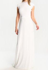 Witte avonddress met een hoge halslijn, korte kapmofjes en een vloeiende rok. Bevat delicate kantaccenten rond de halslijn.