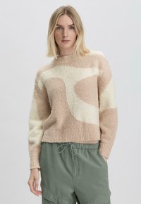Beige en crèmekleurige gebreide trui met een geribbelde halslijn, een zachte textuur en een cropped fit, gecombineerd met groene cargobroek.