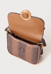 Bruine leren schoudertas met een gouden drukknoopsluiting. Het interieur beschikt over een ritsvak en een gladde tan voering.