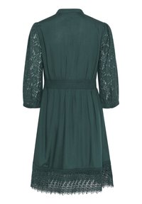Abito verde scuro con vita stretta, maniche in pizzo a tre quarti e orlo in pizzo con dettagli intricati nella parte inferiore.