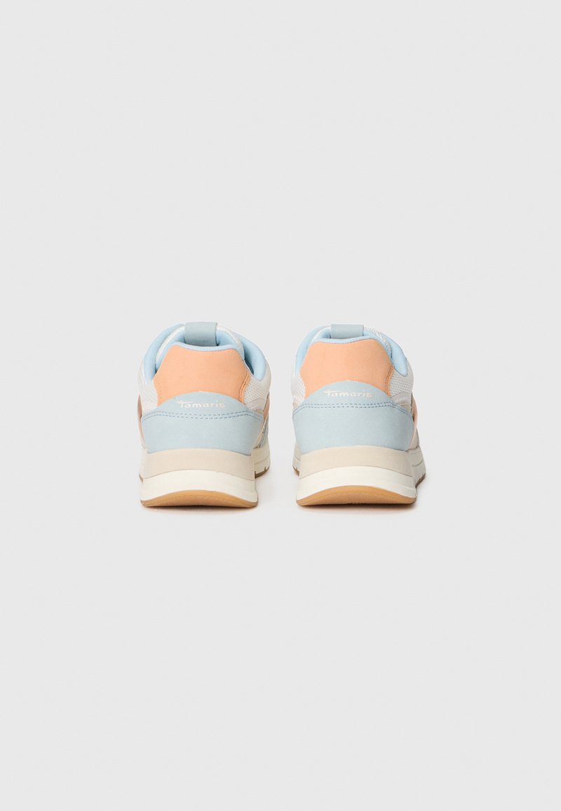 Een paar pastelblauwe, witte en perzik kleurige sneakers zichtbaar vanaf de achterkant op een effen lichtgrijze achtergrond.