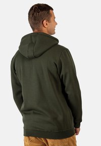 Sudadera de algodón verde con capucha doble, puños y dobladillo acanalados. Textura suave, ofrece una cobertura completa y tiene un corte relajado.