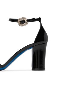 Sandalo con tacco alto in pelle verniciata nera, dotato di un robusto tacco a blocco, cinturino alla caviglia regolabile e una decorativa fibbia con strass. Suola blu.